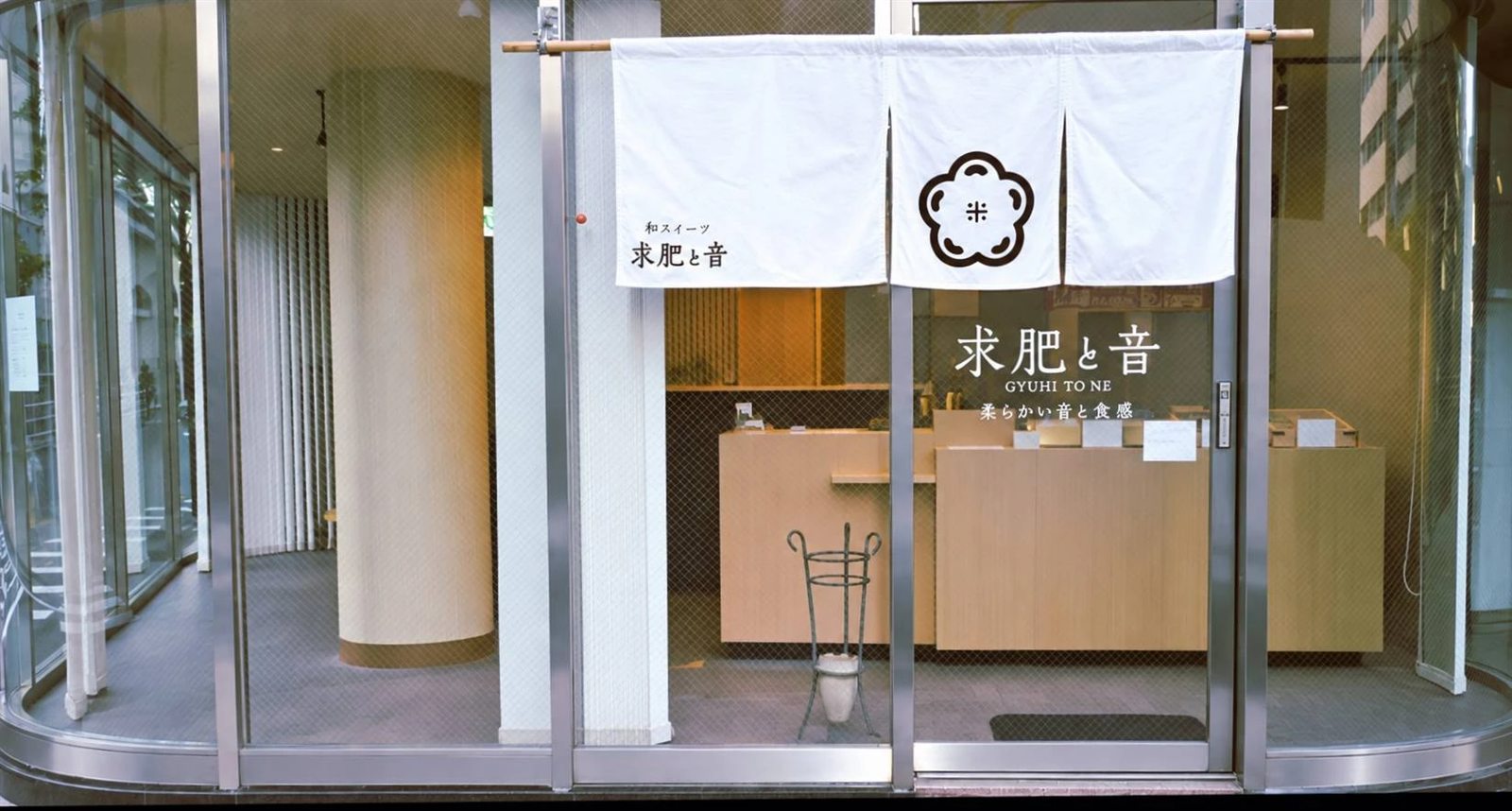 白い暖簾がかかった求肥と音の店構え。ガラス張りの自動ドアが目印です
