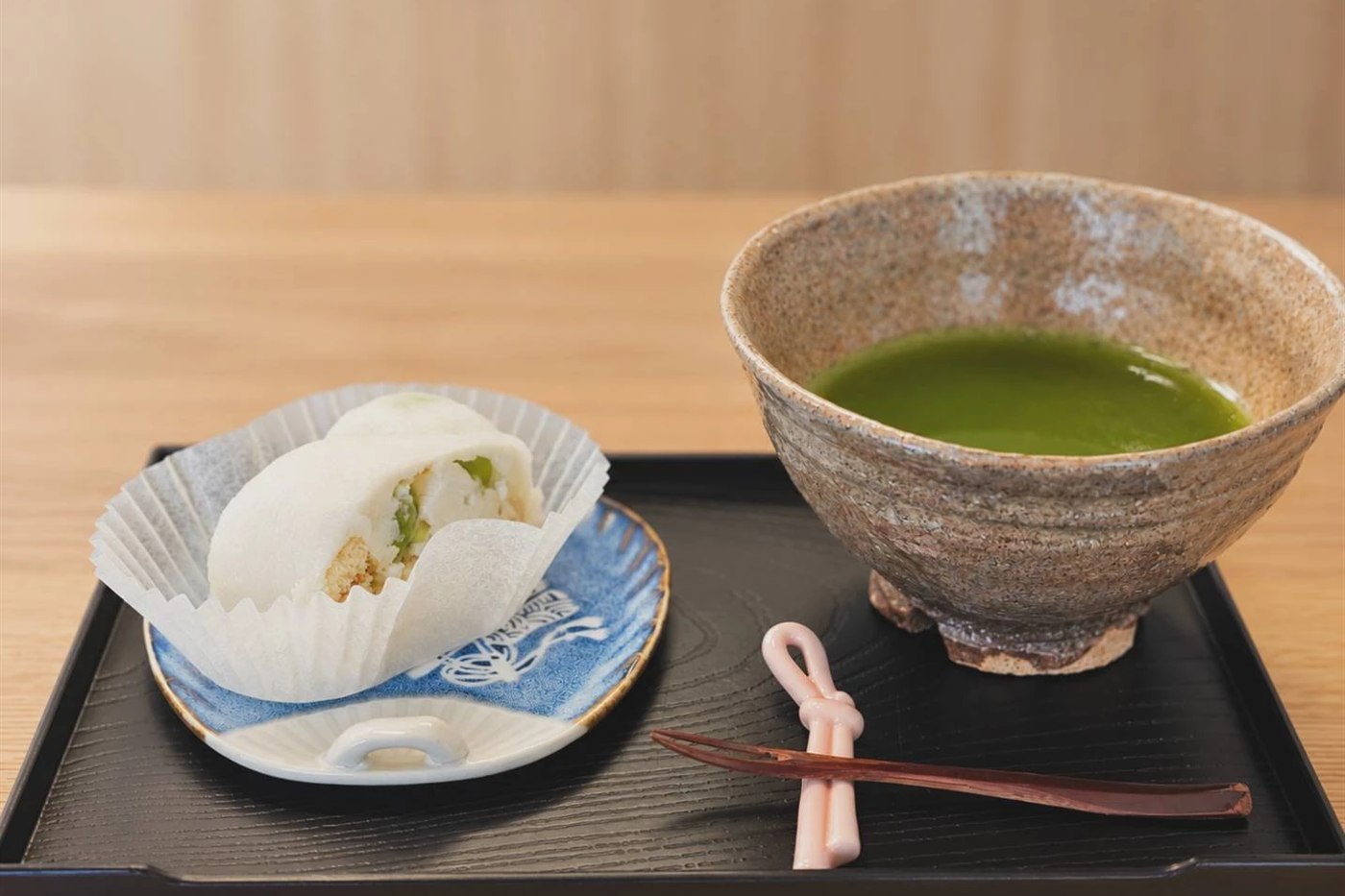 黒い盆にのせた和菓子と、茶碗に点てた抹茶